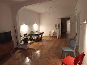 Un coin repas avec une table et des chaises, un téléviseur et une plante en pot.