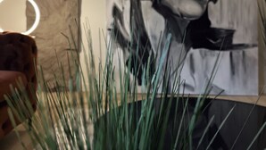 A room with a modern art piece on the wall, a stone pillar, and a potted plant in the foreground. - Private Parking• Stylish Elegance •King bed (Pittsburgh)