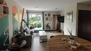 A modern living room with a sofa, coffee table, and potted plants.
