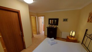 Ein Hotelzimmer mit einem Bett, einem Schminktisch, einem Nachttisch und einer Heizung.