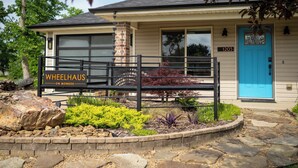 Une maison avec une porte bleue, une cheminée en briques et une enseigne sur laquelle on peut lire : « WHEELHAUS, MONROEVILLE ».