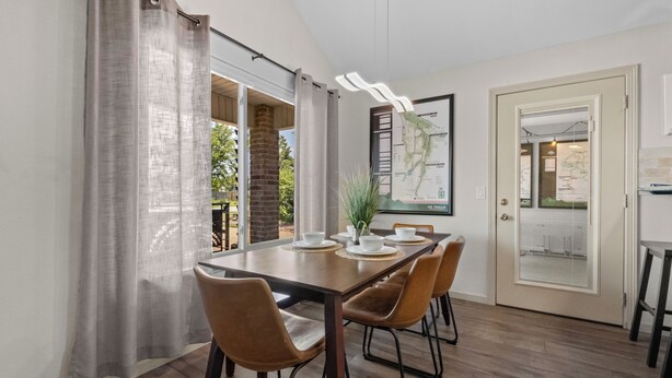 Un coin repas avec une table en bois, six chaises et une carte accrochée au mur.