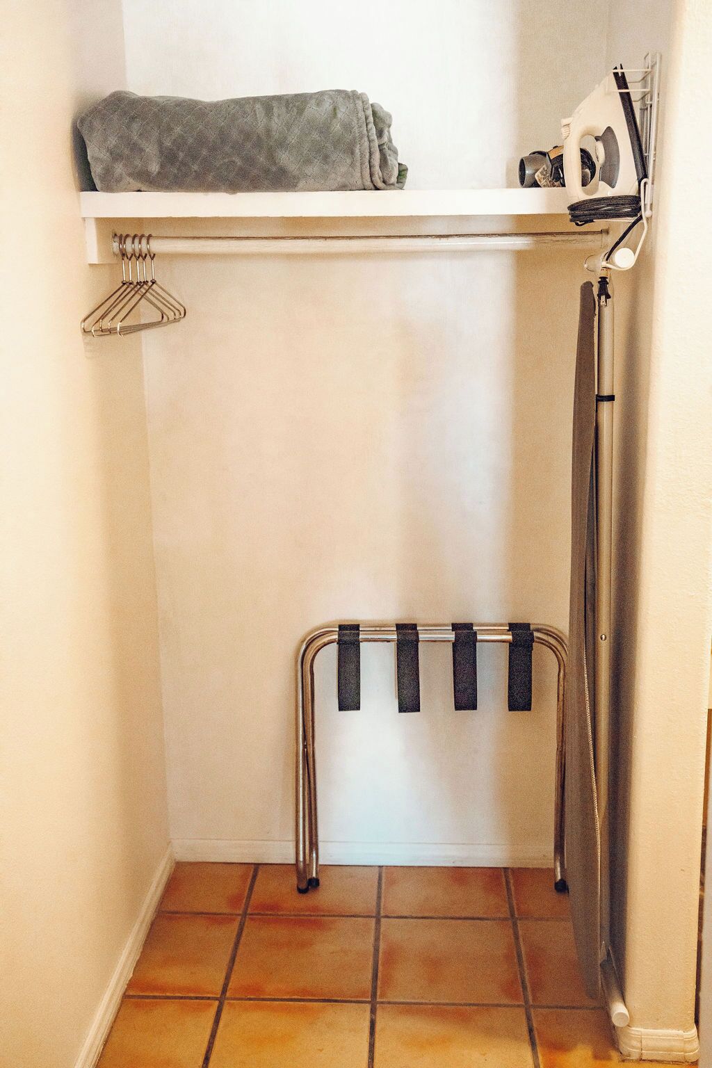 A laundry area with a drying rack, a towel rack, and a washing machine.