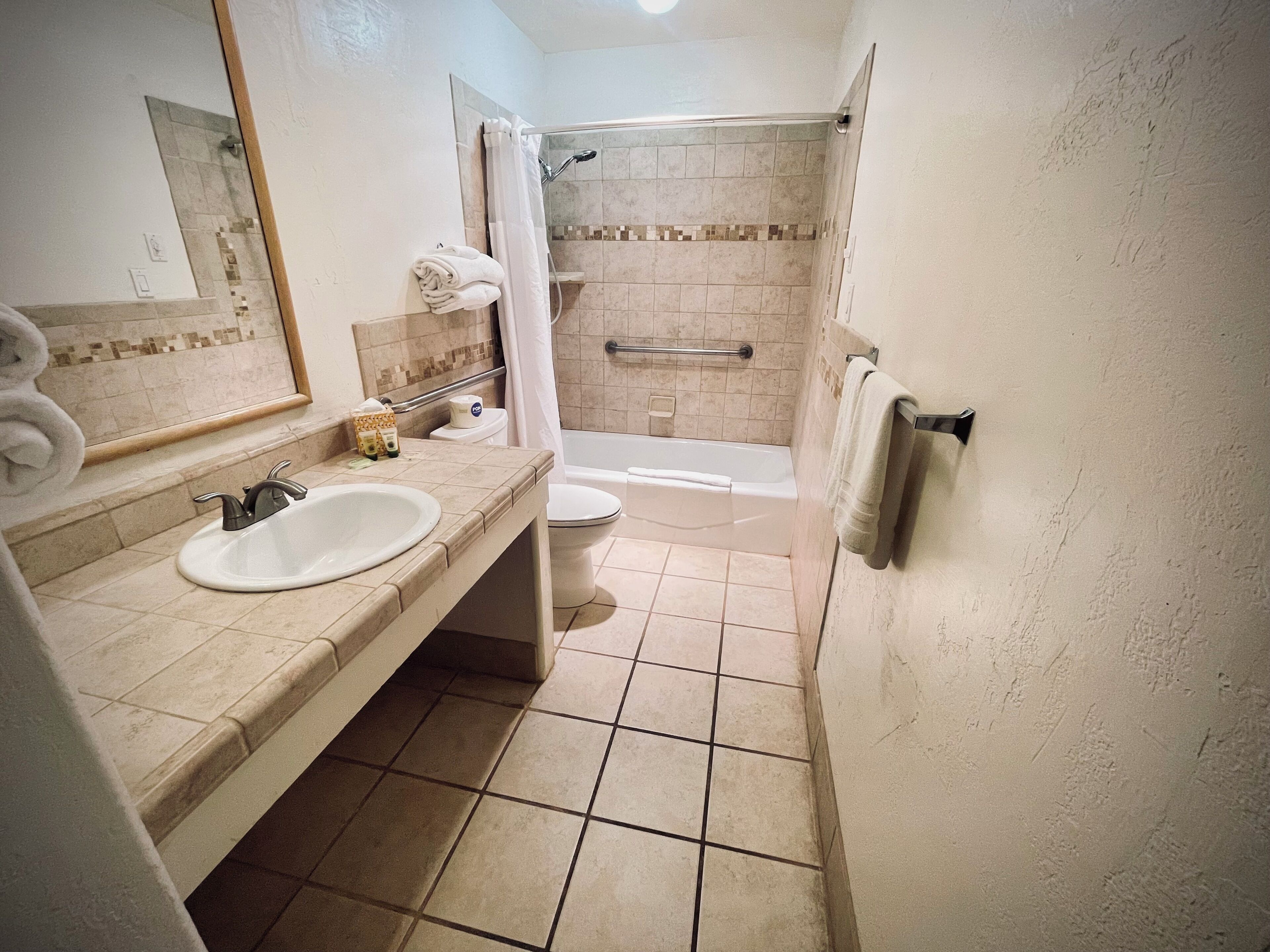Un baño con lavamanos, inodoro y ducha.