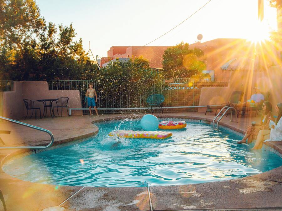 A swimming pool with inflatable toys and a sunlit background.