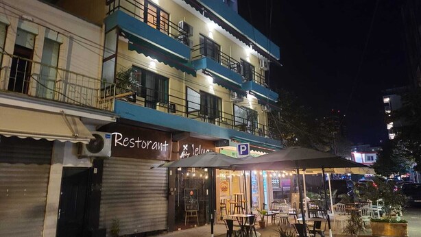 Un edificio de varios pisos con un restaurante en la planta baja.
