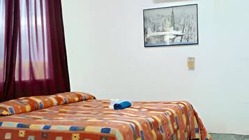 Ein Zimmer mit einem Bett, einem Fenster und einem Wandbild.