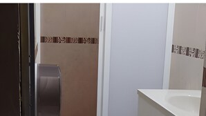Un baño con inodoro, lavabo y dispensador de toallas de papel.