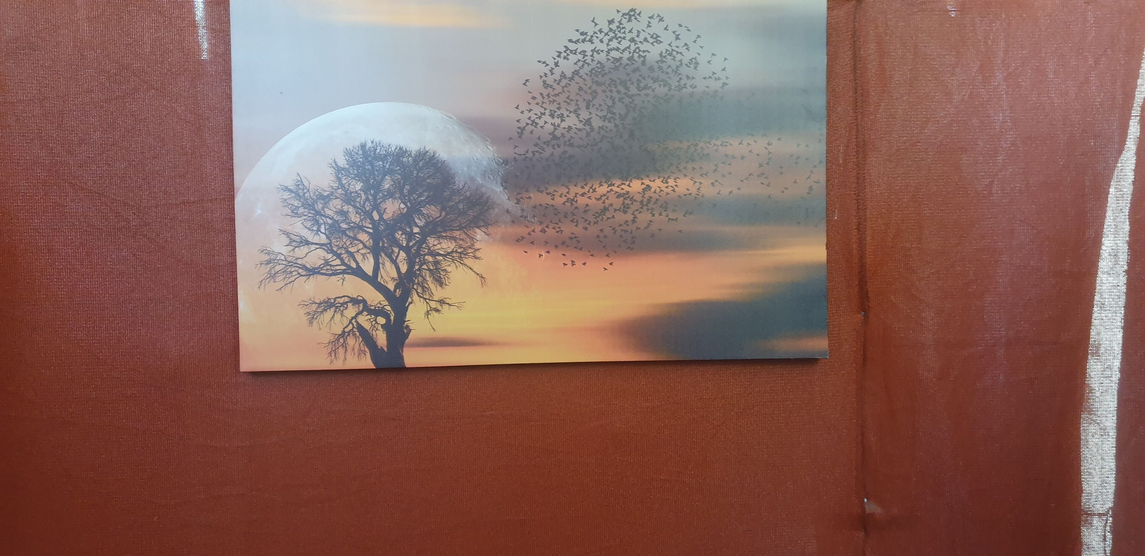 Dipinto raffigurante un albero e uno stormo di uccelli all'ora del tramonto.