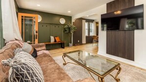 A modern living room with a glass coffee table, a sofa, and a large mirror.