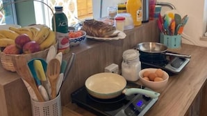 A kitchen counter with various food items, utensils, and appliances. - Angatu Hostel (São Paulo)