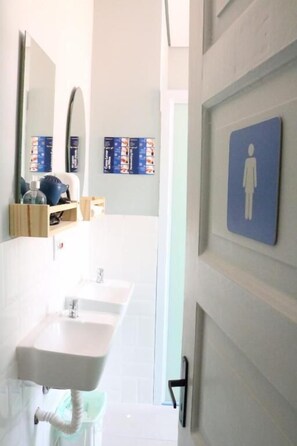 A bathroom with a white sink, a mirror, and a blue sign indicating a women's restroom.