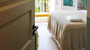 A bedroom with a bed, a wardrobe, and a balcony. - Angatu Hostel (São Paulo)