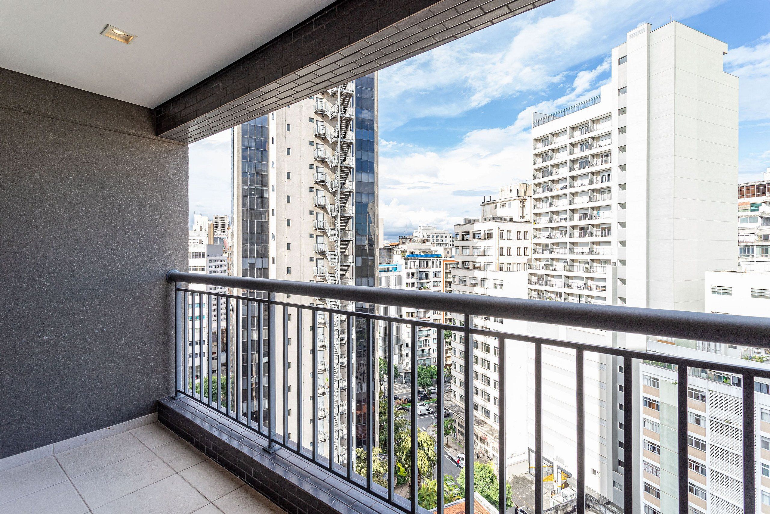 Ein Balkon mit Metallgeländer und Blick auf eine Skyline mit hohen Gebäuden.
