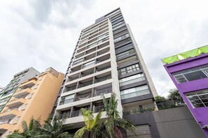 Un immeuble à plusieurs étages, doté de balcons et d’un toit plat.