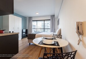 Une chambre d’hôtel moderne avec un coin repas, un lit et une vue sur la ville.