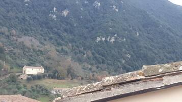 A mountainous landscape with a small building in the valley.