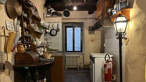 Eine rustikale Küche mit Holzausstattung, einem eingebauten Backofen und einem Fenster mit Blick auf einen Garten.
