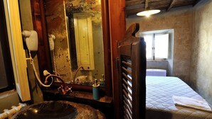 Ein rustikales Badezimmer mit großem Spiegel, Waschbecken und Fenster.
