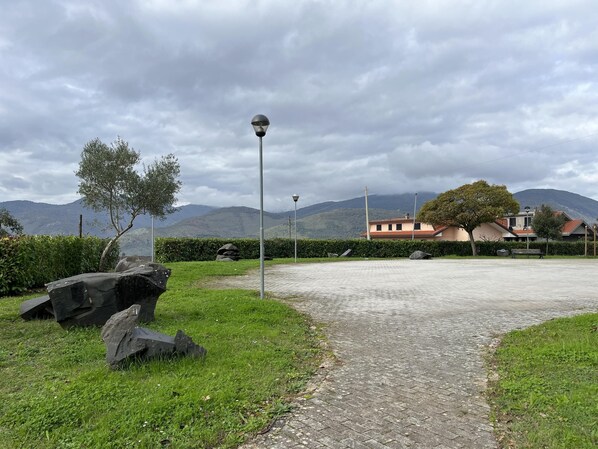 Un sendero pavimentado que conduce a un edificio con vistas a montañas al fondo.
