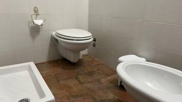 Un baño con inodoro, lavabo y bidé.