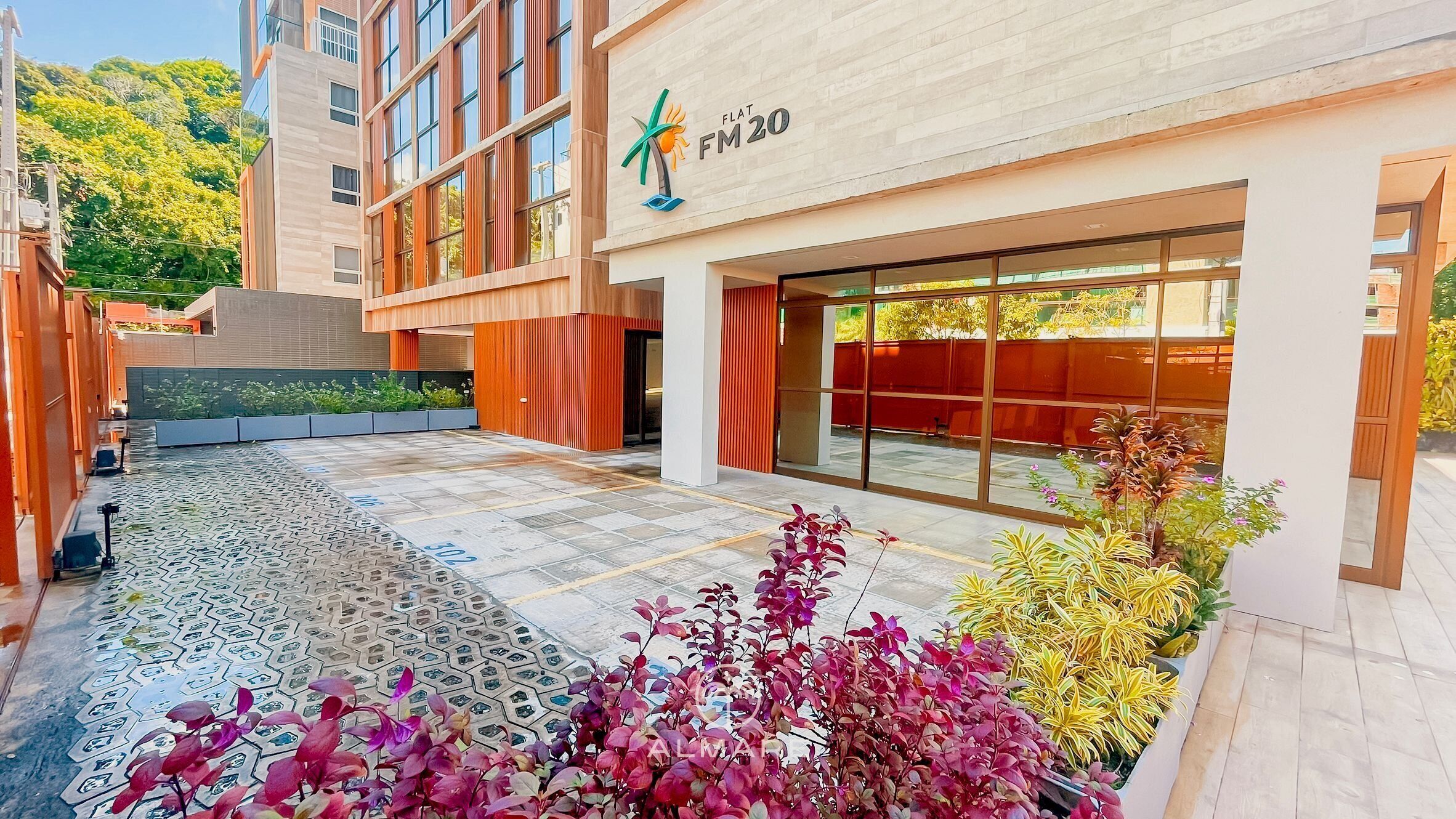 Un edificio moderno con tetto piatto, ampie finestre e un logo con la scritta "FLAT FM20".