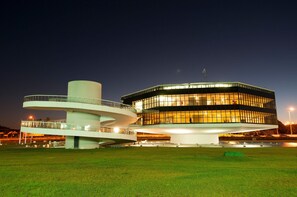 Stunning circular structure with a central tower and flat roof, set amidst a lush green landscape.