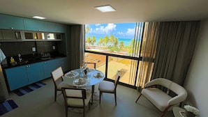 A dining area with a view of the beach and ocean. - Flat FM20 Cabo Branco Light - By Almare (João Pessoa)