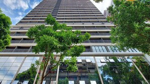 A high-rise building with multiple floors, large windows, and balconies. - Vossa Bossa VN Ueno (São Paulo)
