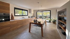 Une cuisine moderne avec des meubles en bois, un four encastré et une grande fenêtre.