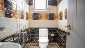 Een badkamer met toilet, wastafel en douche.