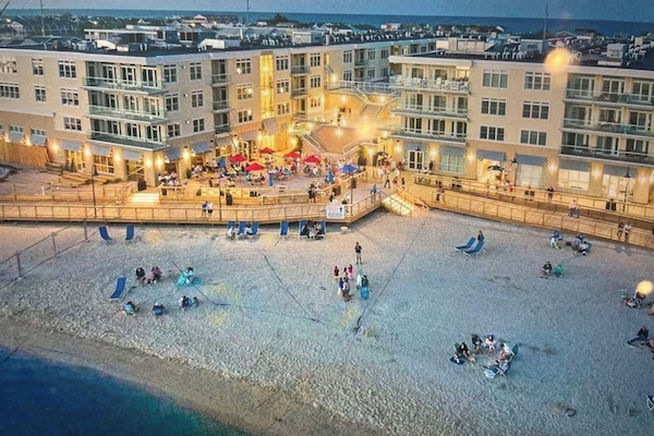 Aerial view of back of building with bay beach and boardwalk areas