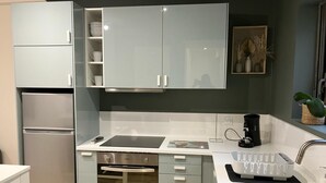 A modern kitchen with a built-in oven, a coffee maker, and a sink. - Appartement Idéal Famille, Belle VUE Mer, Plage du Capelan Accessible à Pieds! (Bandol)