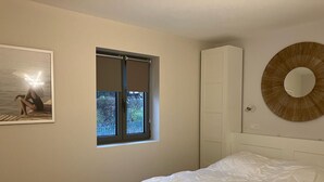 A bedroom with a bed, a window, a wardrobe, and a wall-mounted mirror. - Appartement Idéal Famille, Belle VUE Mer, Plage du Capelan Accessible à Pieds! (Bandol)
