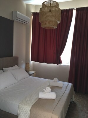 Relax in a cozy retreat with a neatly made bed, bedside table, and ambient lighting.