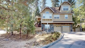A two-story house with a stone foundation, a garage, and a covered porch.