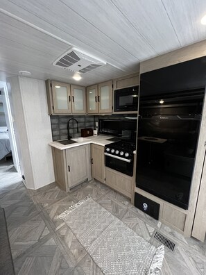 Fridge, microwave, oven, stovetop - Escape to the Smokies: Cozy RV with Queen Bed & Bunk Beds in Scenic Campground (Gatlinburg)