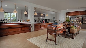 A spacious kitchen with a large island, wooden cabinets, and a variety of food items displayed on the counter.