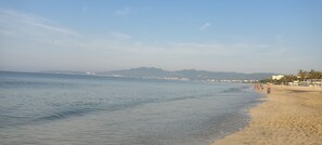 Enjoy leisurely strolls along this wide, scenic beach with gentle waves and breathtaking views of the surrounding mountains and cityscape.