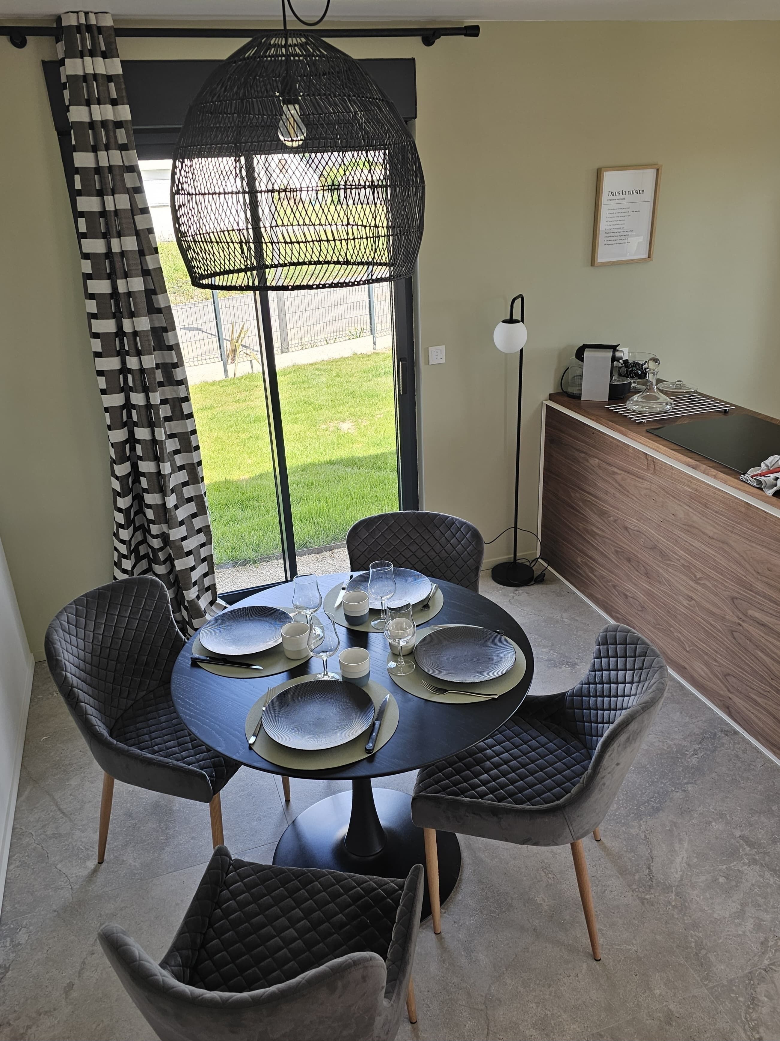 A dining area with a round table set for six, surrounded by six cushioned chairs.