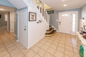 A home interior with a staircase, a door with a pet bone decoration, and a framed picture on the wall. - 4 Play- 5 Bd., Dog Friendly, Game Rm., Private Pool, Easy Bch Access (Virginia Beach)