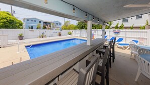 A poolside area with a wooden deck, lounge chairs, and a pool. - 4 Play- 5 Bd., Dog Friendly, Game Rm., Private Pool, Easy Bch Access (Virginia Beach)