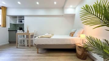 Ein gemütliches Schlafzimmer mit Bett, Nachttisch und kleiner Schreibtischzeile.