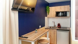 A compact kitchen with a microwave, sink, and wooden cabinets. - David D Angers 53 - One Bedroom Apartment, Sleeps 4 (Paris)