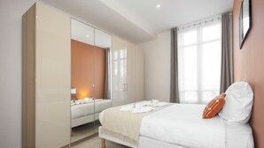Une chambre moderne avec un grand lit, une armoire et une fenêtre avec des rideaux.