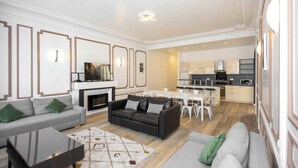 A modern living room with a fireplace, sofa, and dining area. - Daumesnil Grand - Two Bedroom Apartment, Sleeps 6 (Paris)