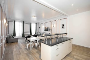 Une cuisine moderne avec un îlot central, un coin repas avec des chaises et un canapé.
