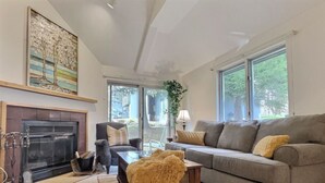 Un salon avec une cheminée, un canapé, une table basse et un tapis.