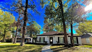 A two-story house with a front porch, a driveway, and a lawn.