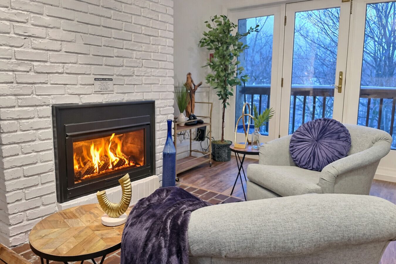 Ein Wohnzimmer mit Kamin, einer Couch, einem Tisch und einer Topfpflanze.